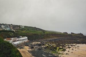 Coastal View with Rocky Beach and Cloudy Sky in St Ives, Cornwall, UK photo