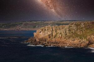 Starry Night Over Rugged Cliffs at Land's End in Cornwall, UK photo
