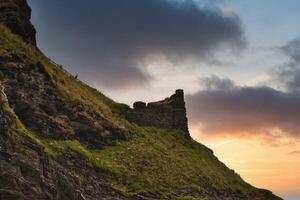 Sunset Over Ancient Cliff Ruins in Tintagel, Cornwall, UK photo