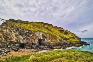 Scenic Coastal Cliff with Cave Entrance in Tintagel, Cornwall, UK photo