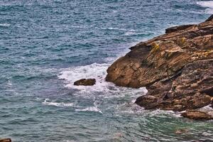 Rocky Coastline with Waves in Tintagel, Cornwall, UK photo
