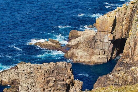 Rugged Cliffs and Deep Blue Ocean at Land's End in Cornwall, UK photo