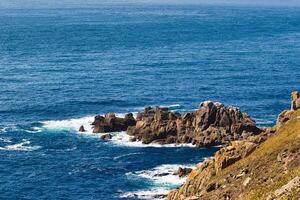 Scenic Rocky Coastline with Ocean Waves at Land's End in Cornwall, UK photo