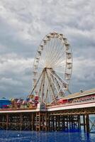 Ferris Wheel on a Pier with Amusement Rides in Blackpool, UK photo