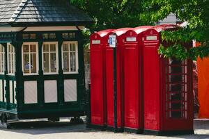 Charming Red Telephone Booths Next to Vintage Kiosk in Harrogate, UK photo
