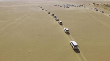 4x4 SUVs cars driving through the sand dunes in the desert of Abu Dhabi. Stock. Top view on SUVs in the desert photo