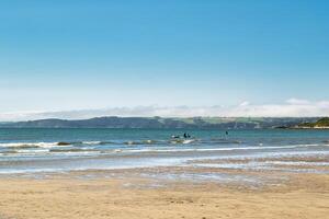 Serene Beach with Gentle Waves and Clear Sky in Cornwall, UK photo
