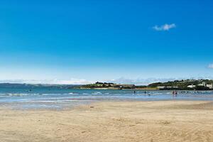 Serene Beach Scene with Clear Blue Sky in Cornwall, UK photo