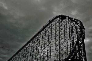 Silhouette of a Roller Coaster Against a Cloudy Sky in Blackpool, UK photo