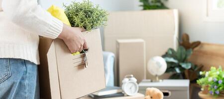 Moving house, relocation. Woman hold carton box contain equipment for new condominium, inside the room was a cardboard box containing personal belongings and furniture. move in the apartment photo