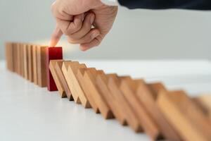 insurance with hands protect domino. Businessman hands stop dominoes falling in business crisis. business risk control and planning and strategies to run prevent insurance businesses. photo