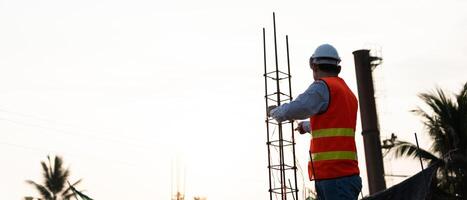 inspector or engineer is inspecting construction and quality assurance new house. Engineers or architects or contactor work to build the house before handing it over to the homeowne photo
