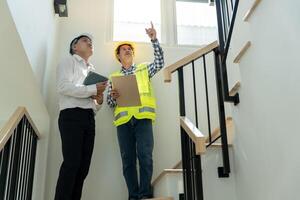 inspector engineer and owner project is inspecting construction and quality assurance new house. Engineers or architects or contactor work to build the house before handing it over to the homeowner photo