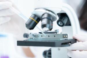 Scientist analyze biochemical samples in advanced scientific laboratory. Medical professional use microscope look microbiological developmental of viral. Biotechnology research in science lab. photo