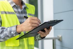inspector or engineer is inspecting construction and quality assurance new house using a checklist. Engineers or architects or contactor work to build the house before handing it over to the homeowner photo