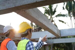 inspector or engineer is inspecting construction and quality assurance new house using a blue print. Engineer or architects or contactor work to build the house before handing it over to the homeowner photo