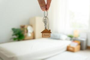 Moving house, relocation. The key was inserted into the door of the new house, inside the room was a cardboard box containing personal belongings and furniture. move in the apartment or condominium photo