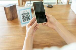 Woman use smartphone to scan QR code to pay in cafe restaurant with a digital payment without cash. Choose menu and order accumulate discount. E wallet, technology, pay online, credit card, bank app. photo