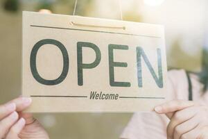 Business woman owner open on the first day of business. guarantees safety, cleanliness, open the coffee shop. open for New normal. Small business, welcome, restaurant, home made photo