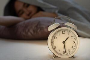 woman in bed late trying to sleep suffering insomnia, sleepless or scared in a nightmare, looking sad worried and stressed. Tired and headache or migraine waking up in the middle of the night. photo