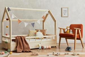 Creative composition of cozy scandinavian child's room interior with wooden bed, plush and wooden toys and textile hanging decorations. Neutral creative wall, carpet on the parquet floor. Template. photo