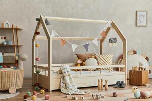 Stylish composition of cozy scandinavian child's room interior with wooden bed, shelf, plush and wooden toys and textile hanging decorations. Neutral creative wall, carpet on the floor. Template. photo