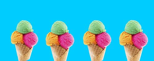 Mixed ice cream scoops in cone on blue background. photo
