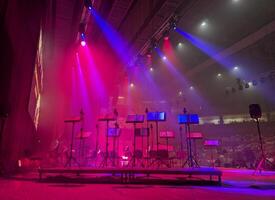 stage with music stands and musical equipment illuminated by beams of stage light photo