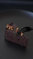 Piece of sweet chocolate cake with nuts on dark concrete background video