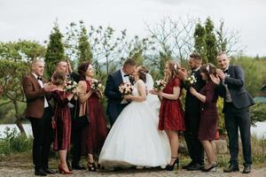 A group of people are posing for a picture, with a bride and groom in the center photo