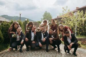 A group of people, including a bride and groom, are posing for a picture photo