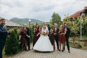 A group of people are posing for a picture, including a bride and groom photo