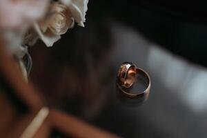 Two gold wedding rings are on a table photo