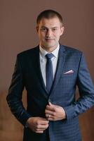 A man in a suit and tie is smiling and holding his jacket open photo