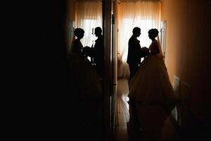 A couple is standing in a hallway, with the bride holding a bouquet photo