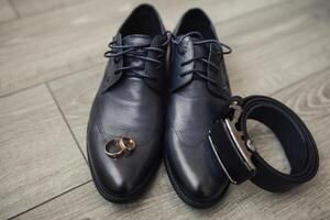 A pair of shoes with a ring on each toe and a belt on the right side photo