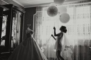 A woman is holding a bunch of balloons and standing in front of a dresser photo