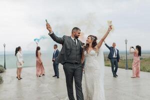 A couple is walking on a beach with a group of people behind them photo