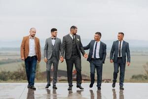 A group of five men are dressed in suits and ties photo