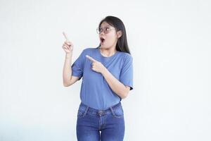 Beautiful Asian woman looks shocked, with a 'wow' expression, pointing to the side with her forefinger photo