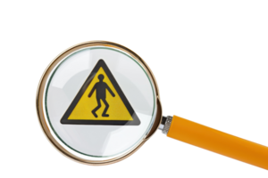 Magnifying glass highlighting a caution sign with a pedestrian symbol, emphasizing safety and hazard awareness. png