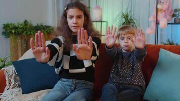 Siblings children girls showing stop gesture, warning of finish, prohibited declining access at home video
