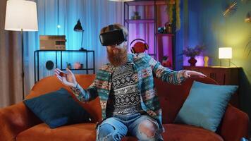 Man using virtual reality futuristic technology headset to play simulation 3D game at home video
