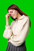 Young Woman Smiling With Eyes Closed, Standing Against a Green Background photo
