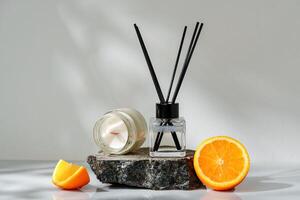 Elegant Aroma Diffuser With Black Reeds on a Slate Base Next to a Fresh Orange Slice photo