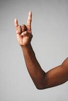 Hand Making the Rock N Roll Sign Against a Plain Gray Background photo