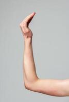 Human Hand Raised Against a Neutral Gray Background in a Studio Setting photo