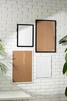 Varied Sized Photo Frames Displayed on a White Brick Wall