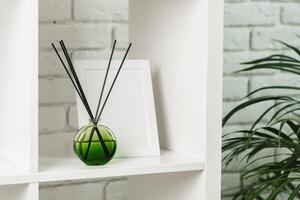 Elegant Reed Diffuser on White Shelf in a Modern Minimalist Interior Setting photo