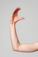 Outstretched Bare Human Arm Against a Plain Gray Background photo